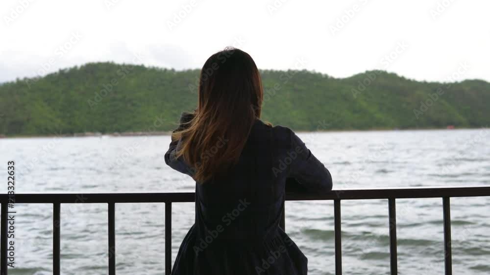Lonely woman sitting absent minded and looking at the lake Lonely woman sitting absent minded and looking at the lake