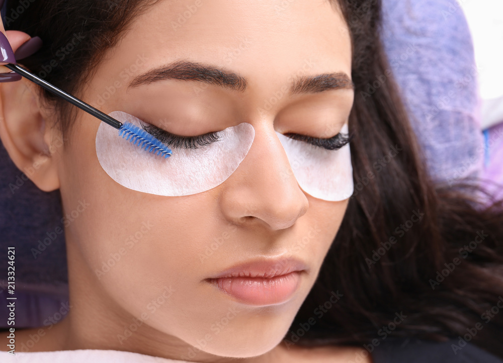 Fototapeta premium Young woman undergoing eyelash extensions procedure, closeup