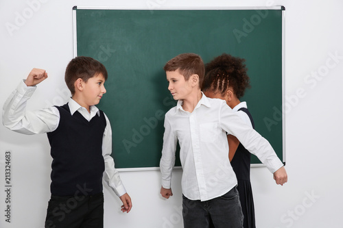 Bilde på lerret Brave little boy protecting girl from bullying in classroom
