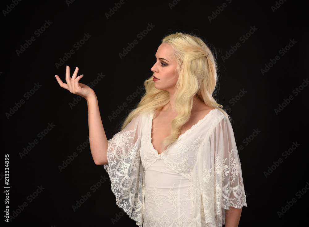 close up portrait of a blonde girl wearing white lace gown. black studio background. close up portrait of a blonde girl wearing white lace gown. black studio background.
