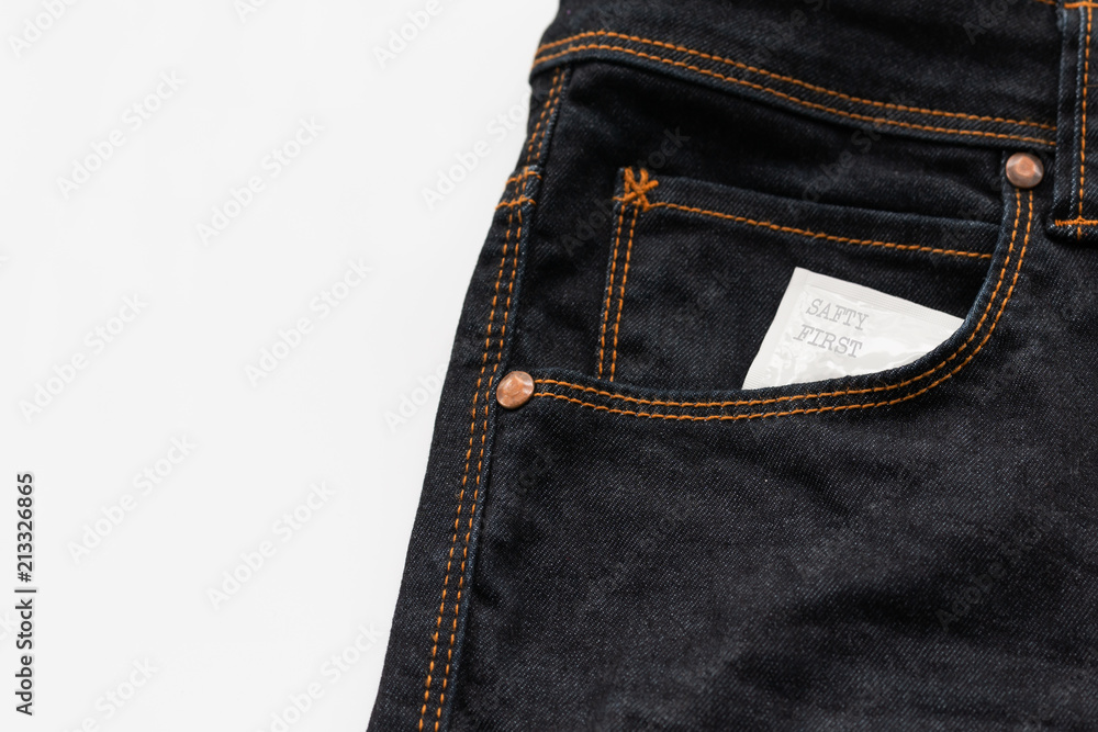 Condom in the jeans pocket with word safty first Condom in the jeans pocket with word safty first