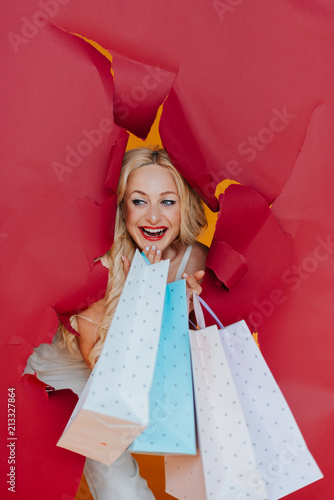 Shopping and free time concept.Beautiful women shopping. She hold many of shopping bags. Portrait of female shopaholic holding paper bags from favorite stores and smiling