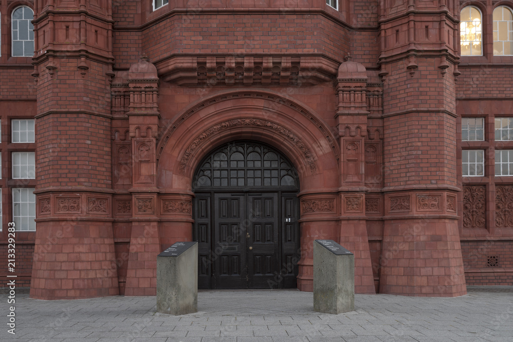 Large black doorway, to a old red brick building. The building houses the Welsh Government, and is located in Cardiff Bay