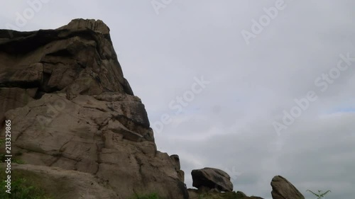 Time-lapse of cloudy sky next to a huge rock photo