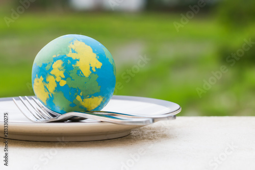 Globe model placed on plate with fork spoon for serve menu in famous hotels. International cuisine is practiced around the world often associated with specific region country. World food inter concept