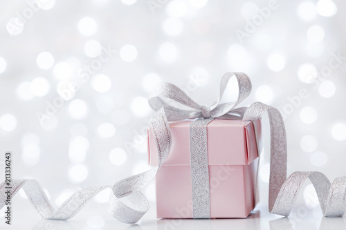 Present or gift box against bokeh background. Holiday greeting card on Birthday or Christmas.
