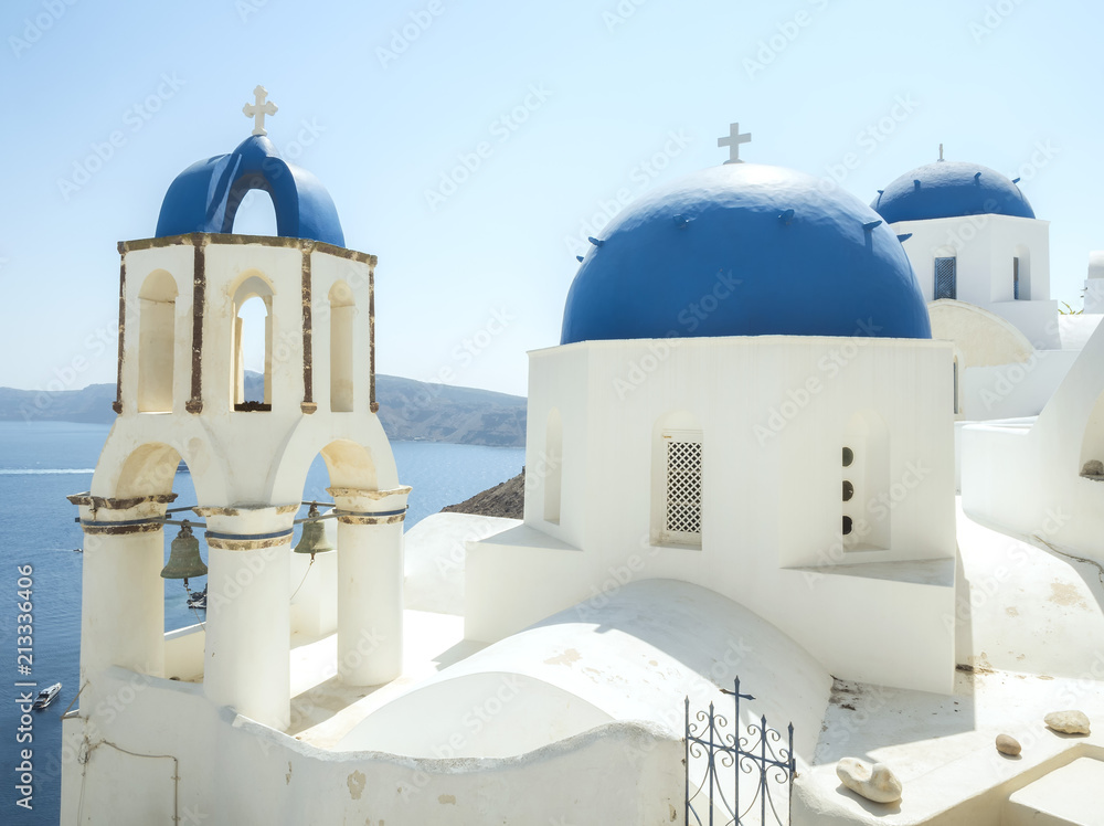 White Church with bells and blue dome at Oia, Santorini, Greek Islands