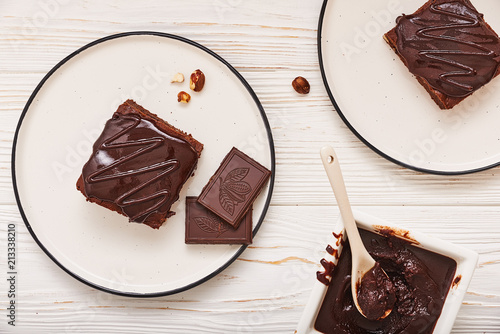 homemade chocolate brownies on white wooden background, top view