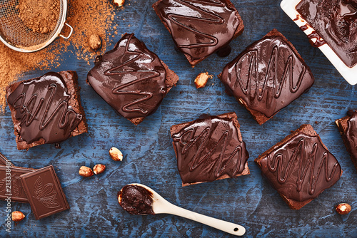 homemade chocolate brownies on dark blue background, top view
