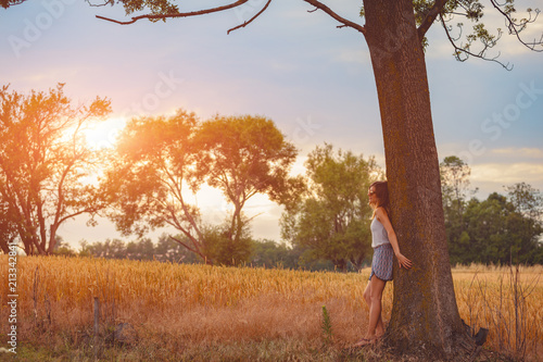 Cute smiley girl embracing the oak tree in nature. photo