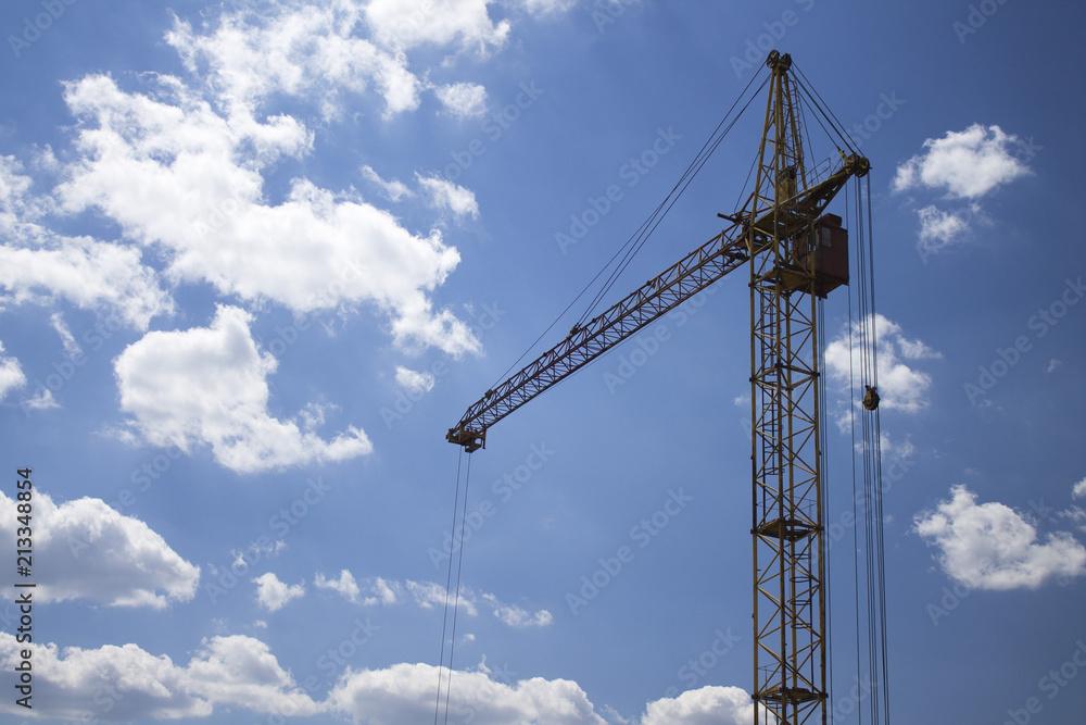 Photo of construction crane against a blue sky background Photo of construction crane against a blue sky background