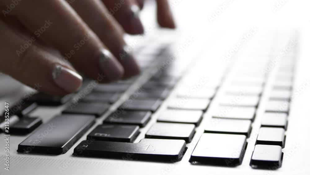 Fingers typing on a laptop, blue tone Fingers typing on a laptop, blue tone