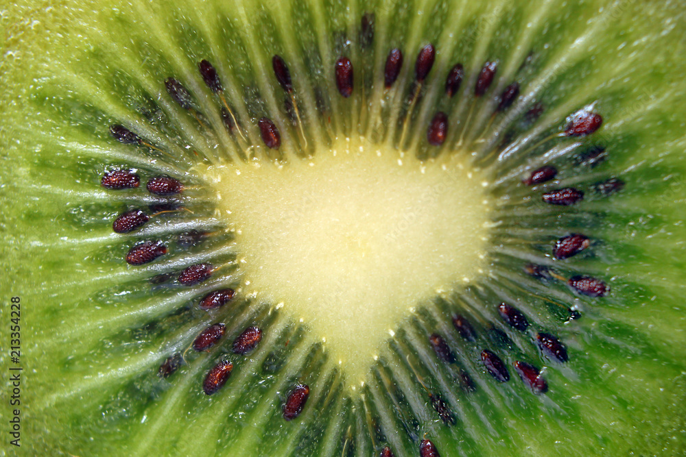 Kiwi fruit cut into two pieces against a light background, close-up