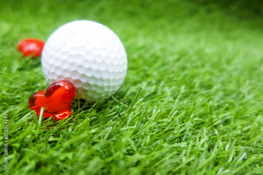 Golf ball with heart shape for golfer lover are on green grass Golf ball with heart shape for golfer lover are on green grass