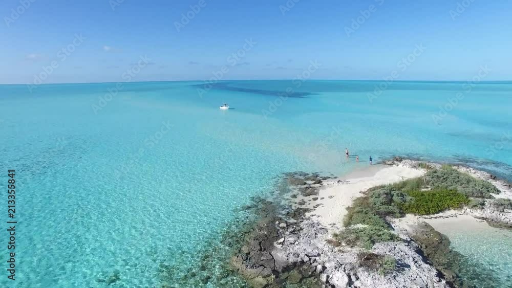 4K Aerial -- Incredible Blue Waters of the Bahamas, deserted island and boat flyover, people walking in the water. 4K Aerial -- Incredible Blue Waters of the Bahamas, deserted island and boat flyover, people walking in the water.