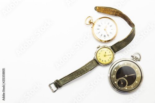 Set of watches on white background with a classic gold pocket watch a black and silver pocket watch and a wristwatch with worn leather straps