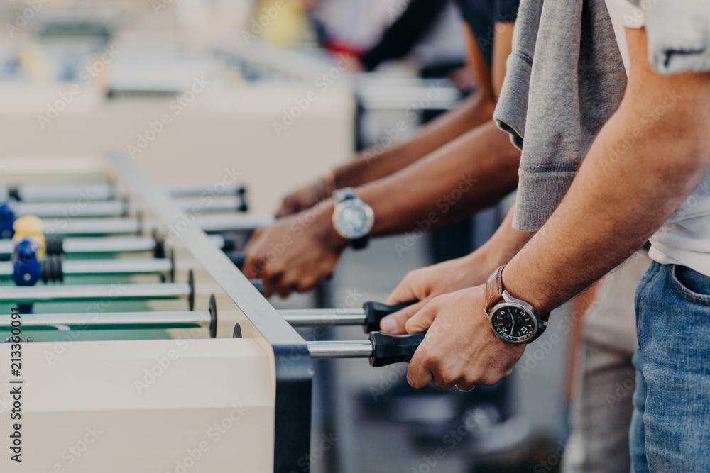 People and recreation time concept. Young people enjoy playing table football, have spare time for entertainment, being friendly team People and recreation time concept. Young people enjoy playing table football, have spare time for entertainment, being friendly team