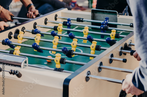 Obraz na plátně Friends play table football game, spend free time in entertainment center