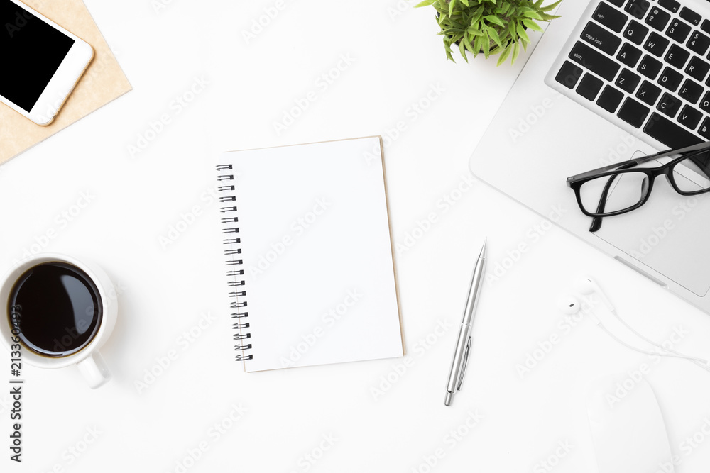 Notebook with blank page is in the middle of white office desk table with supplies. Top view, flat lay. Notebook with blank page is in the middle of white office desk table with supplies. Top view, flat lay.