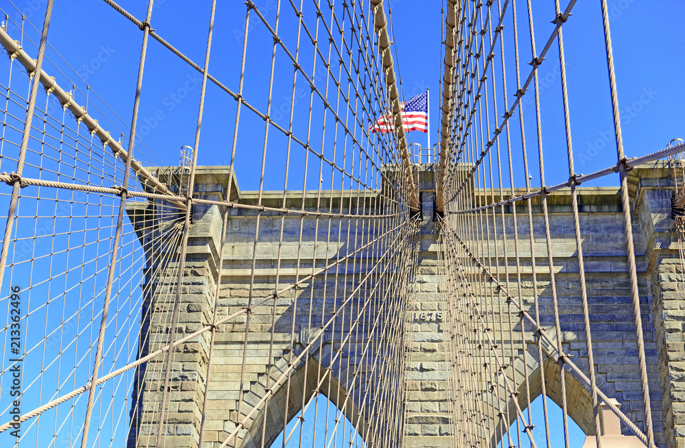Obraz premium Zbliżenie na Brooklyn Bridge i American Flag nad East River, Nowy Jork, USA