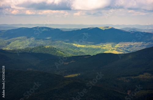 beautiful mountainous landscape background. peaceful nature scenery. clouds over the ridge and light on the forested hill 