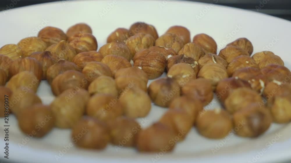 Roasted hazelnut nuts rotating on a plate. Toasting hazelnuts inside microwave Roasted hazelnut nuts rotating on a plate. Toasting hazelnuts inside microwave