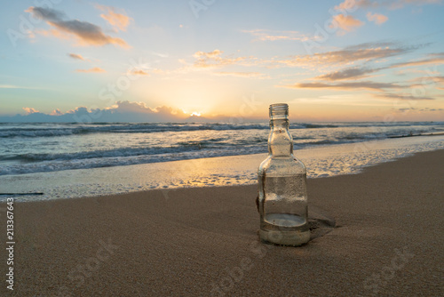 Glass bottle with beatiful beach sunset landscape