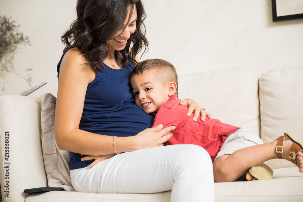 Boy Showing Love Towards Unborn Baby In Mother's Tummy