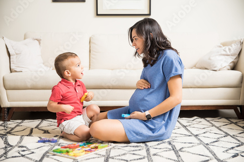 Pregnant Mother Spending Time With Son In Living Room