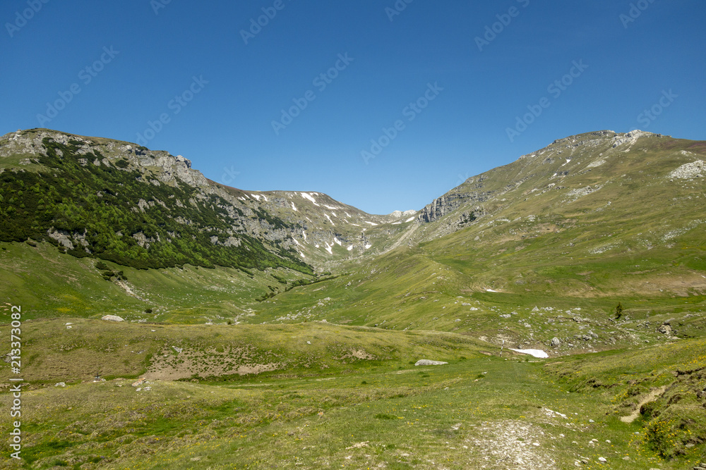 View of Bucegi Mountains, Bucegi National Park, Romania, clear blue sky, few clouds, sunny summer day, perfect for hiking