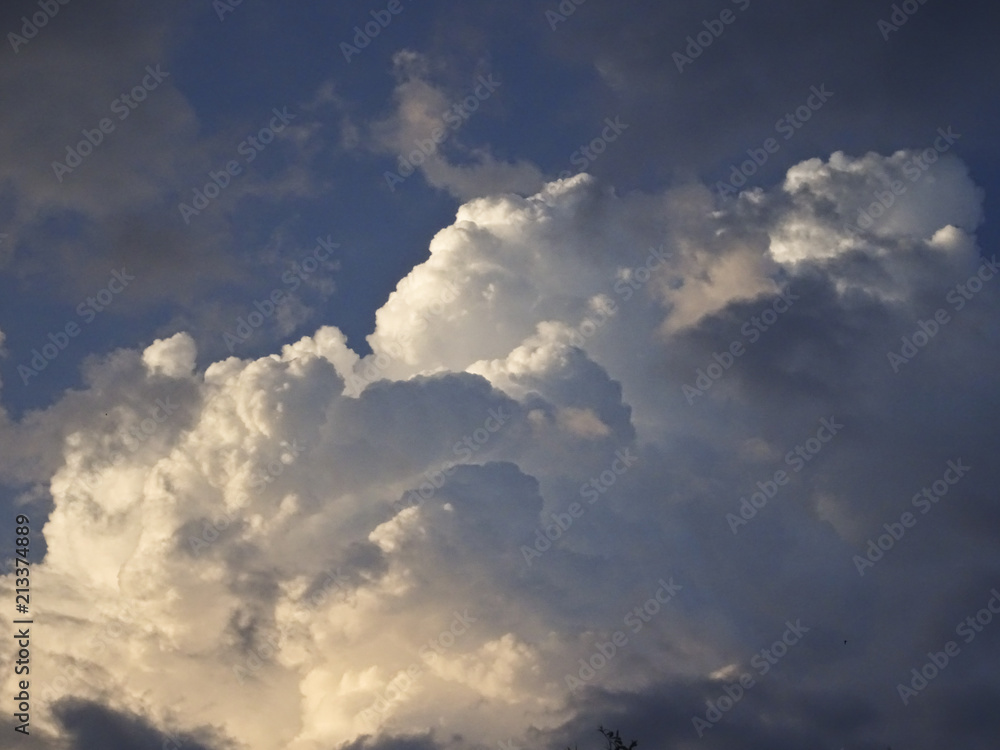 Beautiful cumulus clouds against the blue sky, lit by the sun