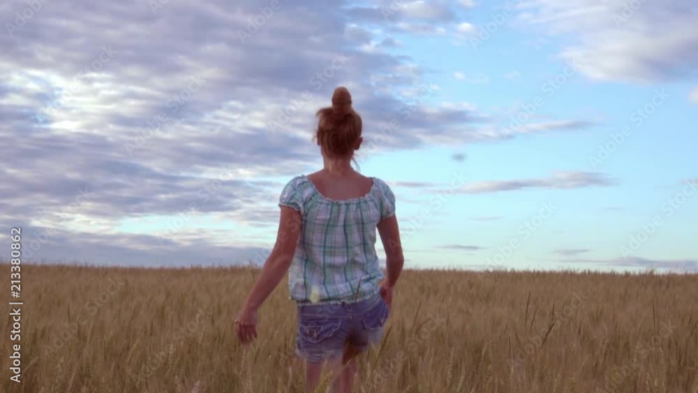 Happy girl running on the field of wheat in the evening. Happy girl running on the field of wheat in the evening.