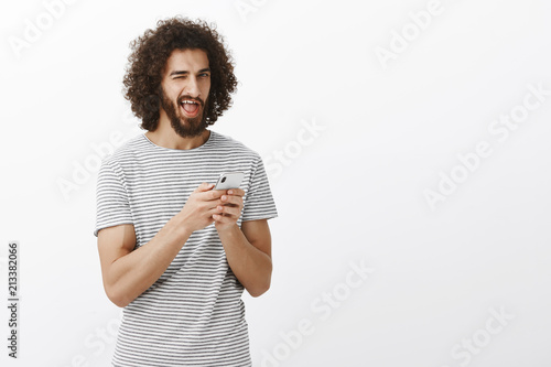 Bild auf Leinwand Indor shot of carefree happy young male student with beard and afro hairstyle, h