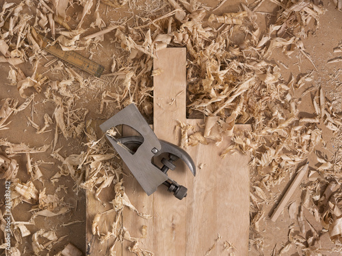 Woodworking iron plane on wooden cutting board and wood shavings. For woodworkers. Blank space for logo or text. Top view. photo