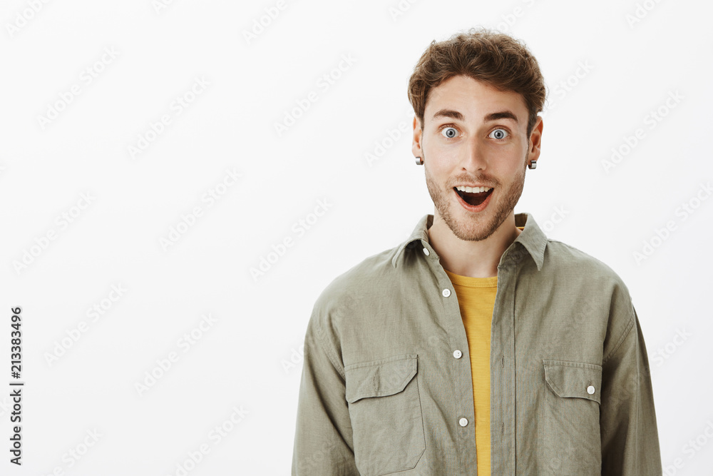 Superheroes fan being amazed hearing about new film. Portrait of impressed and thrilled handsome unshaven man in casual outfit, gasping and smiling, being amused and pleased with incredible great news Superheroes fan being amazed hearing about new film. Portrait of impressed and thrilled handsome unshaven man in casual outfit, gasping and smiling, being amused and pleased with incredible great news