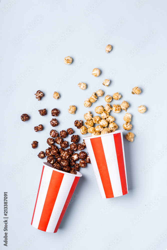 Sweet caramel chocolate popcorn in paper striped white red cup