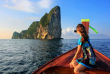 Young woman sitting in the front of a longtail boat going to Phi Phi Leh Island, Krabi Province, Thailand