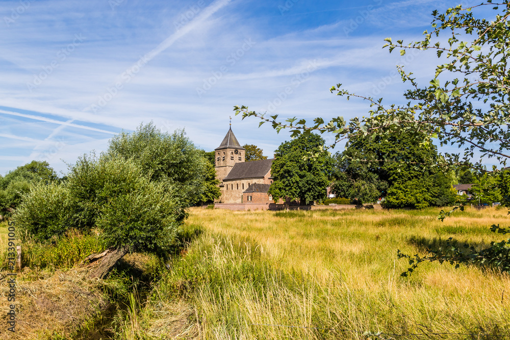 Dutch landscape with an ancient Roman church and a road in Oosterbeek in the Netherlands Dutch landscape with an ancient Roman church and a road in Oosterbeek in the Netherlands