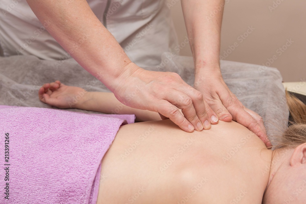 the masseur gives the child a back massage the masseur gives the child a back massage