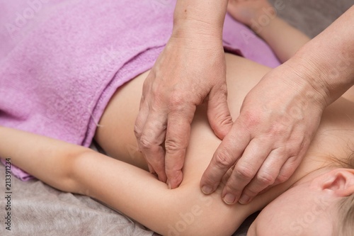 the masseur gives the child a back massage