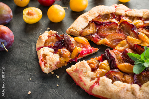 Galette Plum on the Black Background Summer Fruit Cake Fresh Baking Place Copying photo