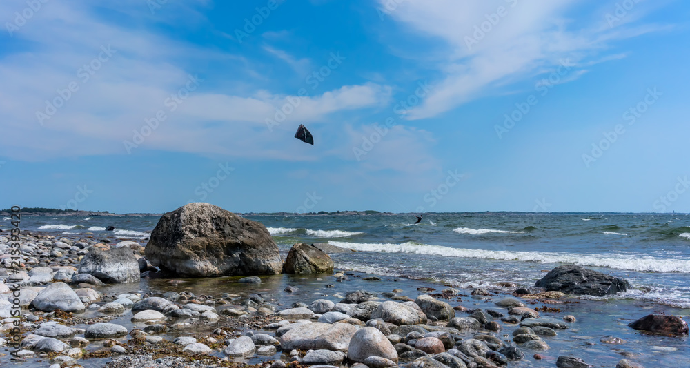Toroe stone beach in Stockholm archipelago with a kite surfer in background Toroe stone beach in Stockholm archipelago with a kite surfer in background