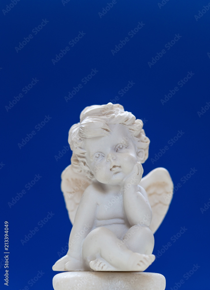 Figurine Of Baby Angel On Blue Background