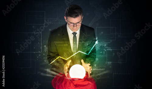 Young businessman making predictions of the future of the stock market with a magic ball
