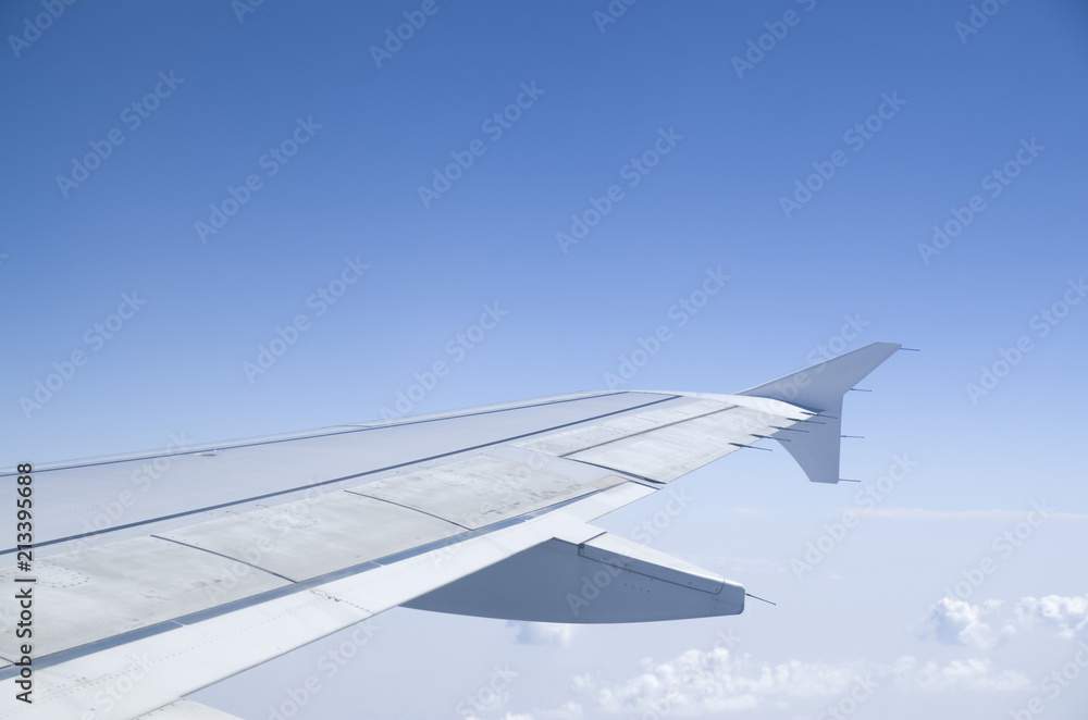 Airplane wing in the cloudy sky Airplane wing in the cloudy sky