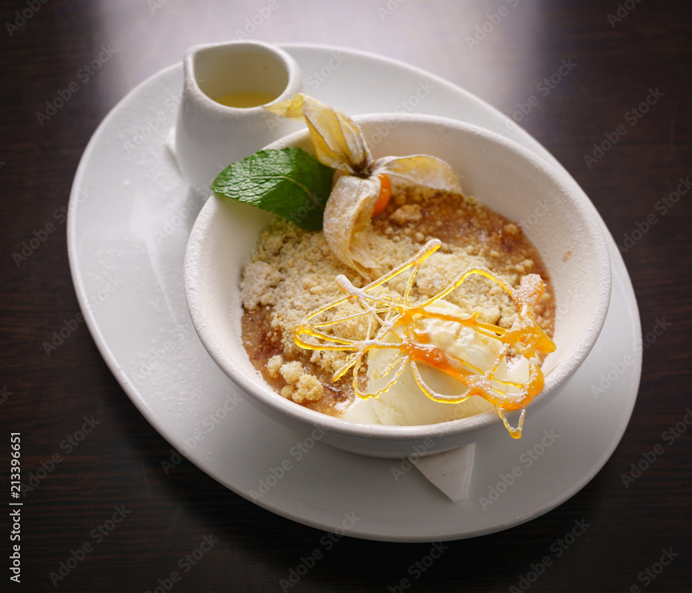 Hot Apple Crumble Served With Handmade Vanilla Ice Cream, Strawberry, Spun Sugar, and a jug of pouring cream Hot Apple Crumble Served With Handmade Vanilla Ice Cream, Strawberry, Spun Sugar, and a jug of pouring cream
