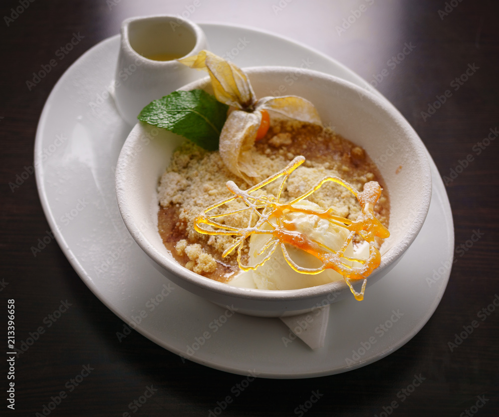 Hot Apple Crumble Served With Handmade Vanilla Ice Cream, Strawberry, Spun Sugar, and a jug of pouring cream Hot Apple Crumble Served With Handmade Vanilla Ice Cream, Strawberry, Spun Sugar, and a jug of pouring cream