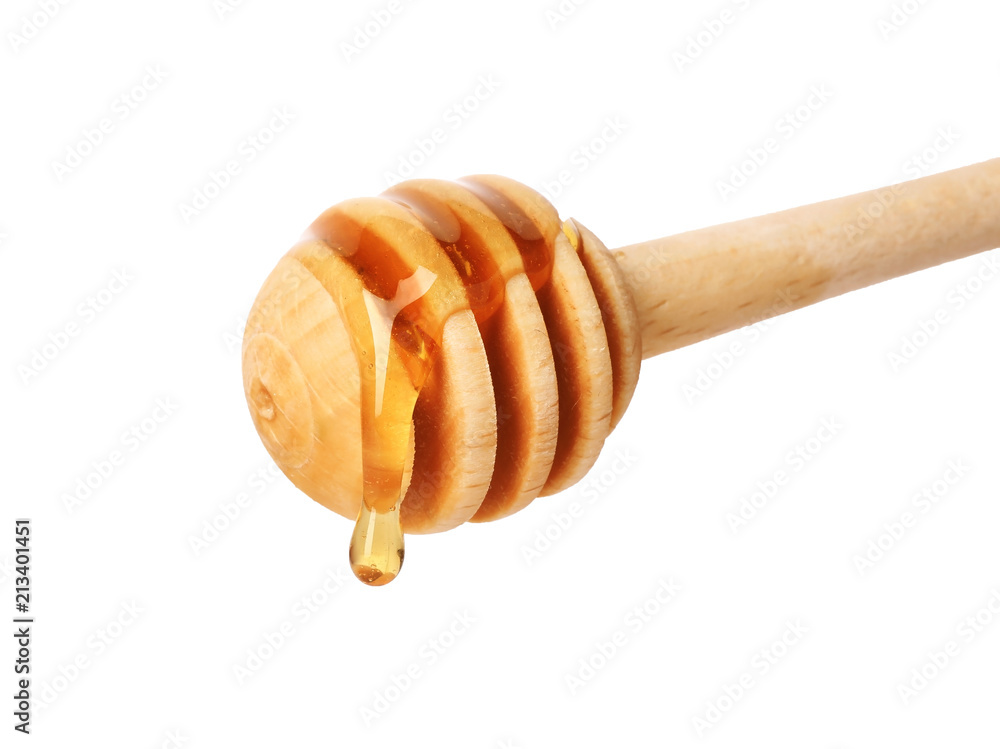 Honey dripping from dipper on white background