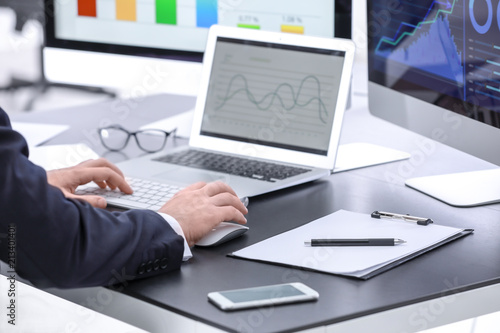 Male broker working in offi...