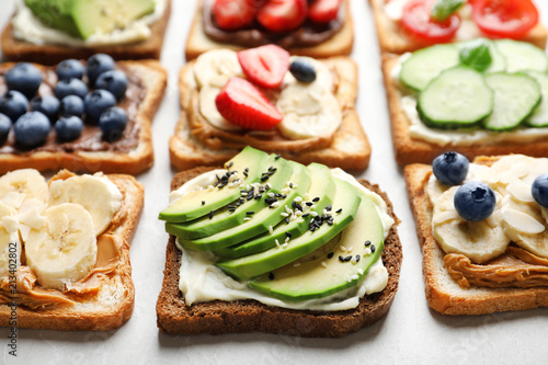 Tasty toast bread with fruits, berries and vegetables on light background, closeup